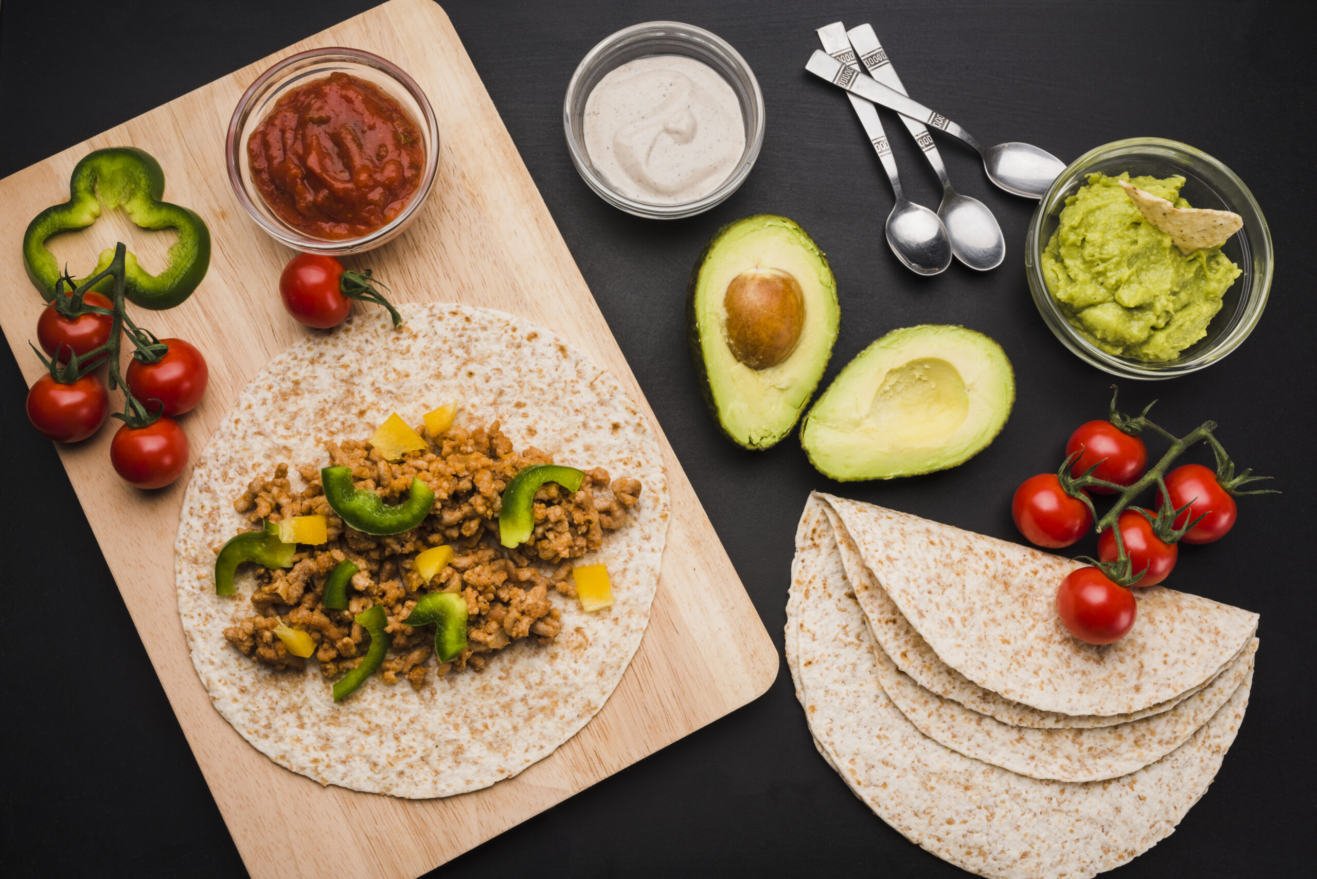 preparation-tacos-cutting-board-near-vegetables-sauces